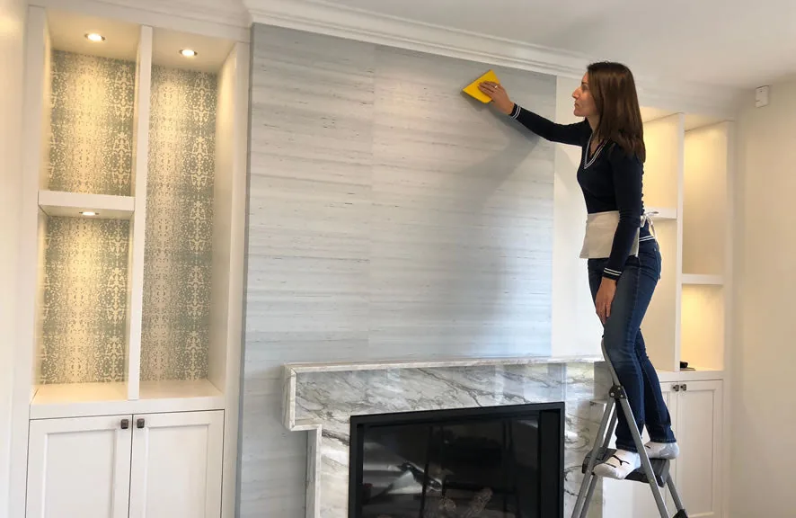 Wallpaper installer carefully smoothing a patterned wallcovering into place